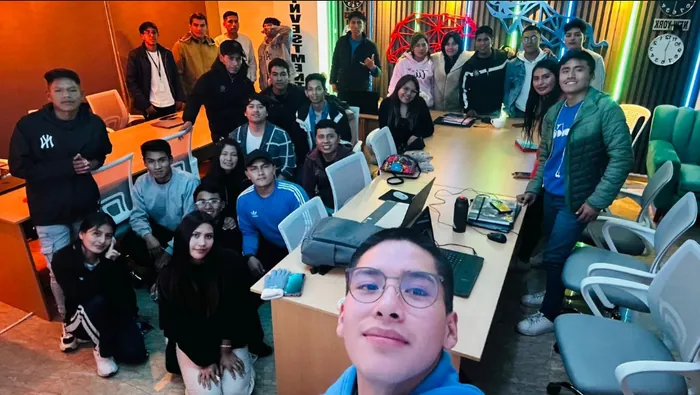 Estudiantes en una sala de trabajo con equipos informáticos