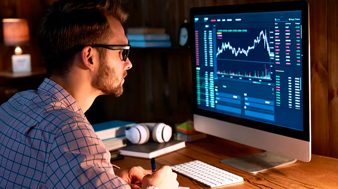 Persona analizando información de los mercados financieros en la pantalla de un ordenador